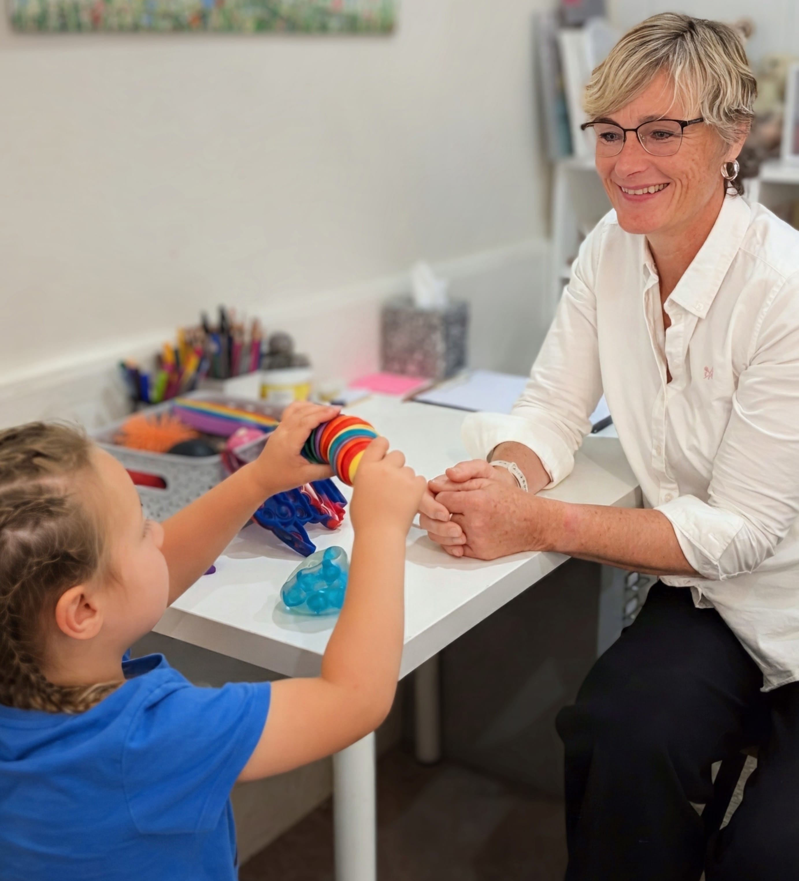 Children's counselling children's counsellor sitting with hcild playing with toy